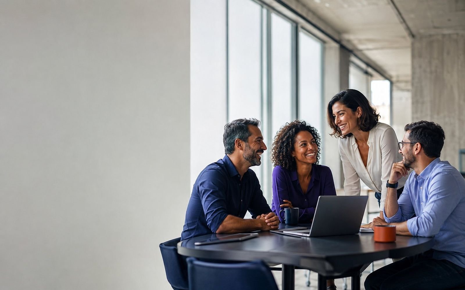 Parceiros da Sempre Fácil conversando em volta de uma mesa com notebook